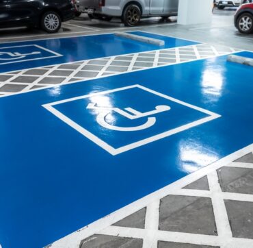 Car parking lot reserved for handicapped driver in supermarket or shopping mall. Car parking space for disabled people. Wheelchair sign paint on parking area. Blue and white handicapped parking lot.
