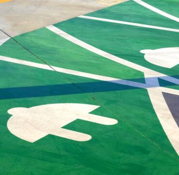Electric plug sign on green and white concrete floor to show the charging service area for electric vehicles in public area