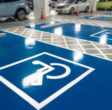 Car parking lot reserved for handicapped driver in supermarket or shopping mall. Car parking space for disabled people. Wheelchair sign paint on parking area. Blue and white handicapped parking lot.