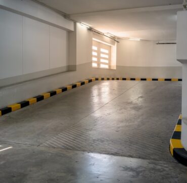Concrete road and ramp with yellow and black curb in building